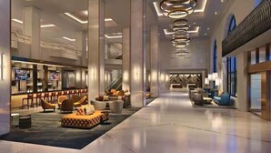 A spacious lobby with a bar area, seating arrangements, and a staircase leading to upper levels.