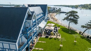A waterfront hotel with a balcony, outdoor seating, and a view of the water. - Best Western Plus Hôtel Le Roof (Vannes)