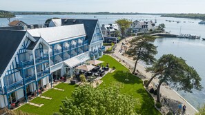 A waterfront hotel with a terrace and outdoor seating area. - Best Western Plus Hôtel Le Roof (Vannes)