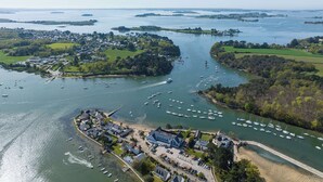 An aerial view of a coastal town with a marina filled with boats, surrounded by green fields and residential areas. - Best Western Plus Hôtel Le Roof (Vannes)