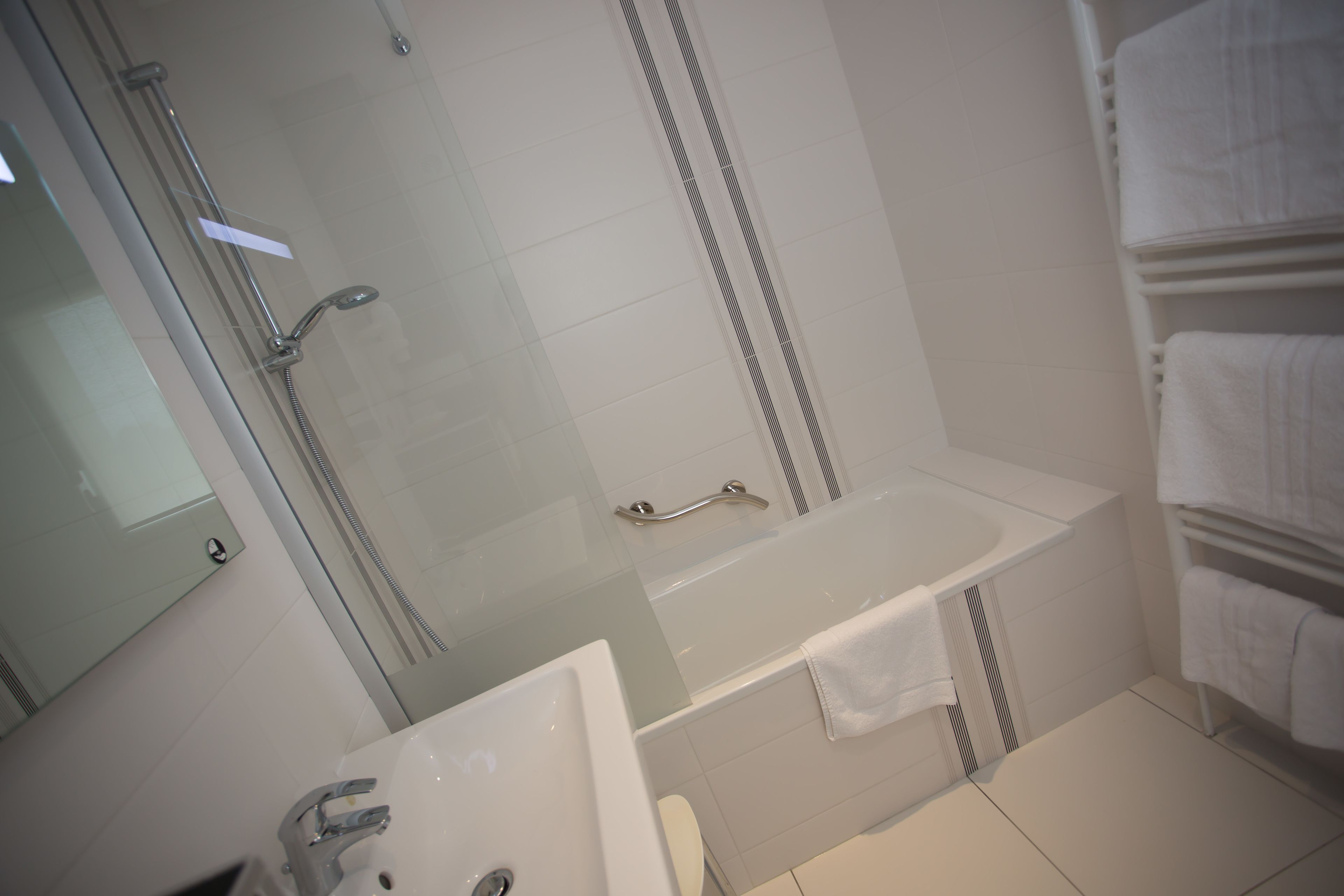 Un baño moderno con ducha acristalada, bañera y lavabo.