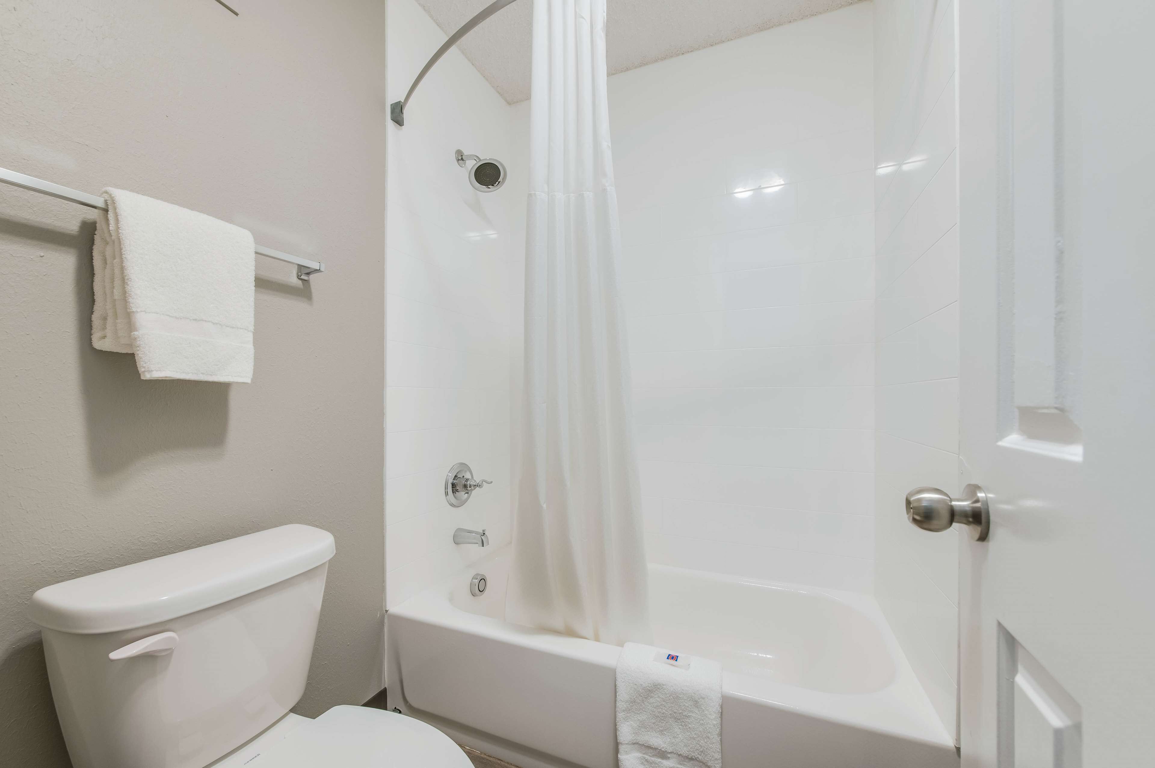 A bathroom with a toilet, a bathtub, and a shower curtain.