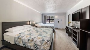 A hotel room with two beds, a desk with a TV, and a window with curtains. - Motel 6 Kilgore, TX (Kilgore)