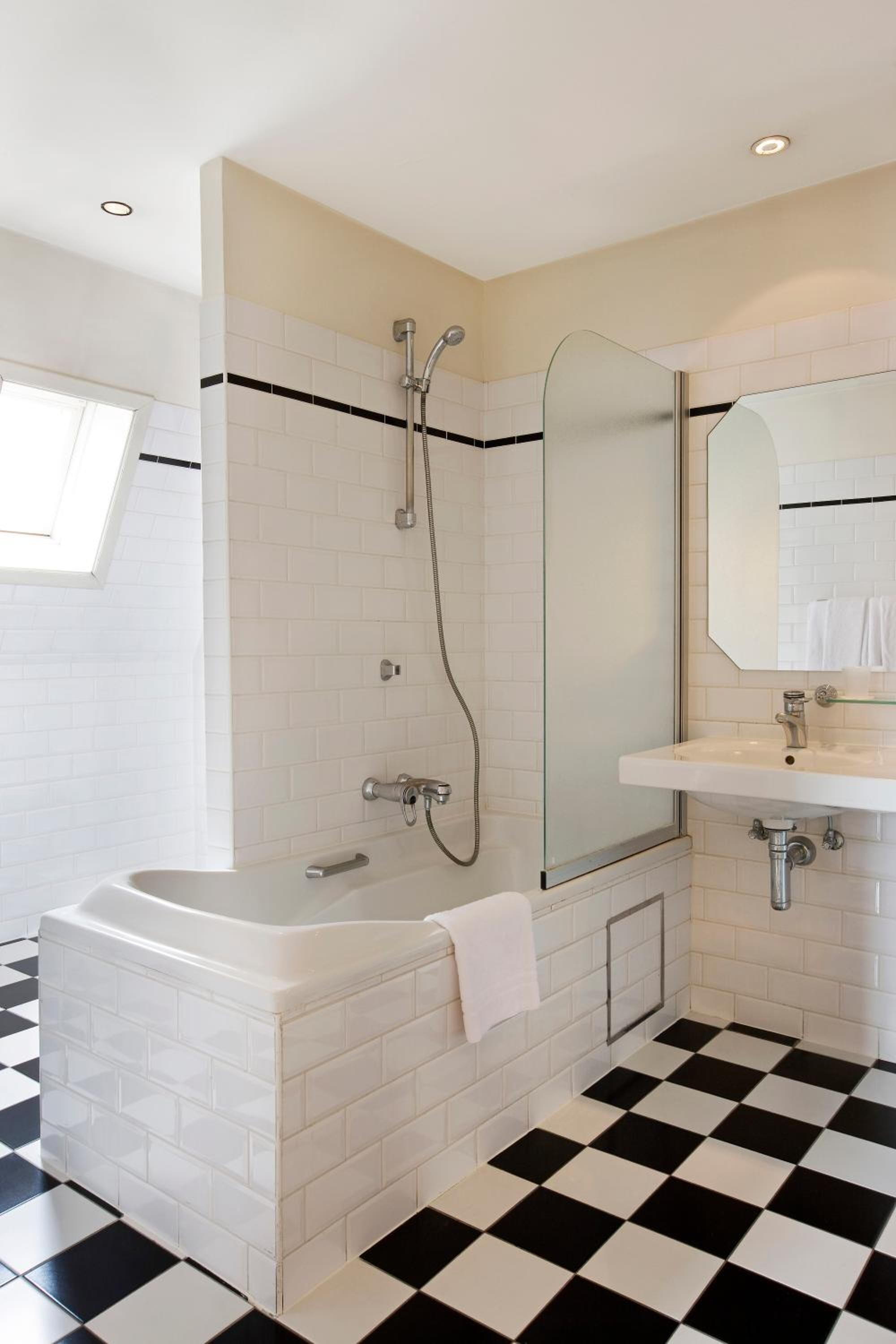 A modern bathroom with a bathtub, a shower, and a sink.