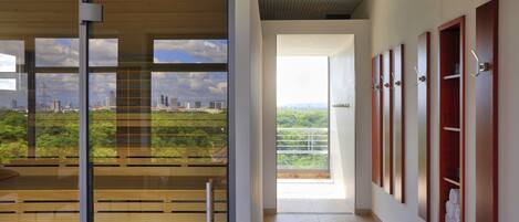 A modern hotel corridor with a view of a cityscape through large windows.