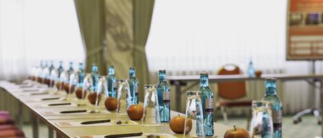 A conference table with water bottles, apples, and nameplates.