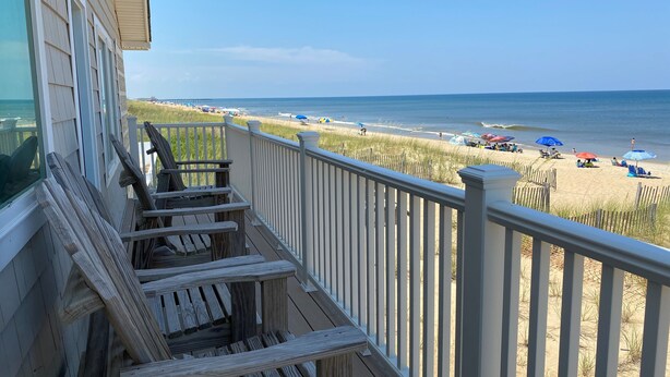 A wooden deck with a view of the beach. - Mariner Inn and Suites (Kill Devil Hills)