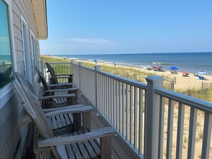 A wooden deck with a view of the beach. - Mariner Inn and Suites (Kill Devil Hills)