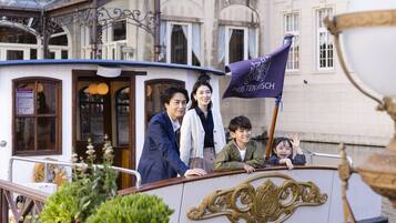 A boat with passengers, a flag, and ornate details.