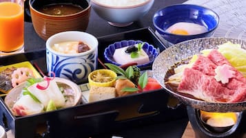 Una comida tradicional japonesa con varios platos y una bebida.
