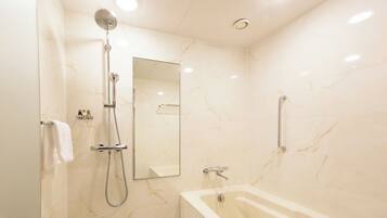 A modern bathroom with a walk-in shower, a standalone bathtub, and a large mirror.