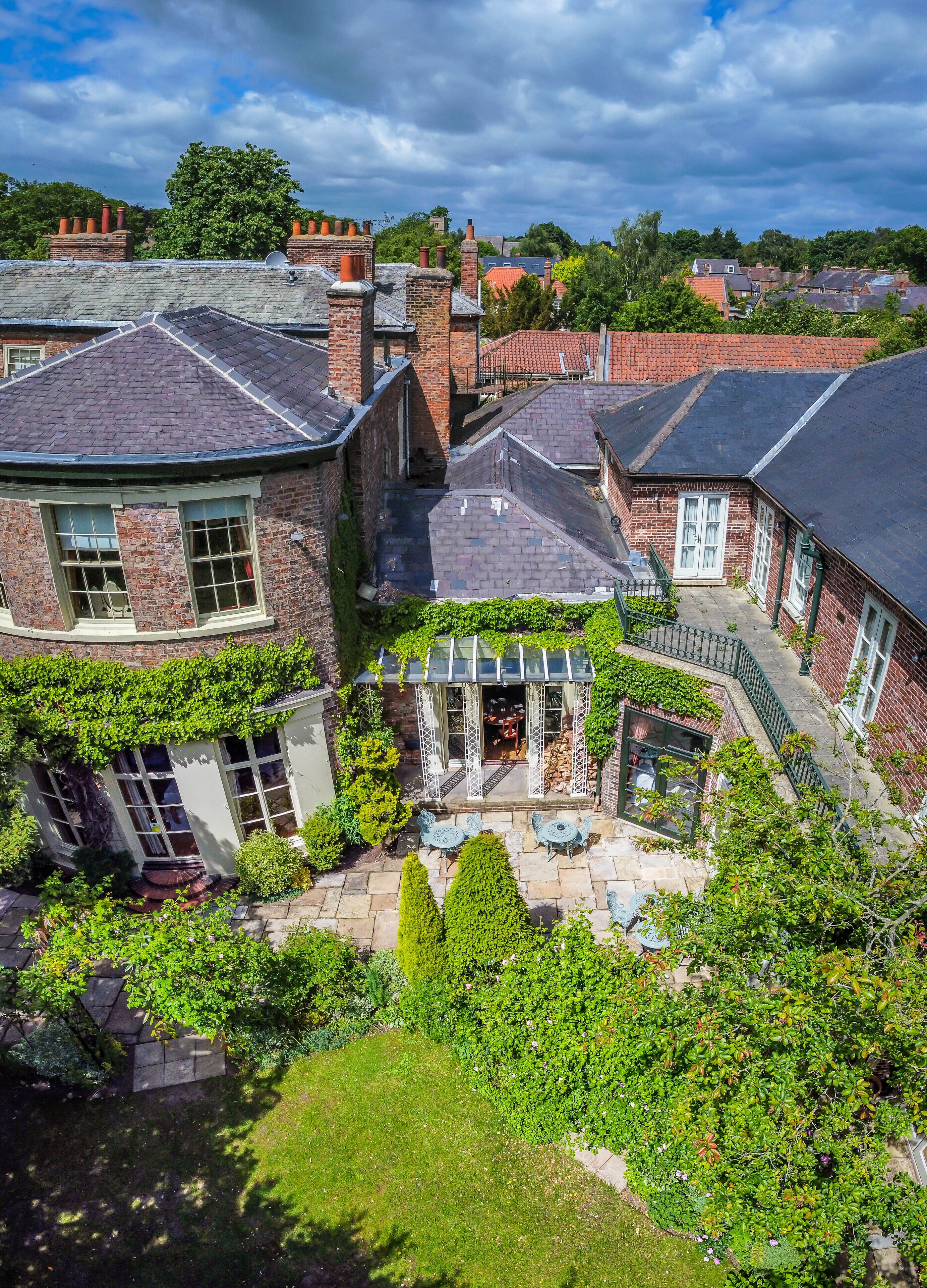 A residential area with brick houses, a garden with a patio, and a conservatory.