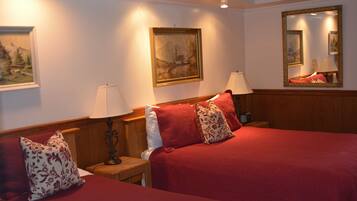 A hotel room with two beds, wooden headboards, and a large mirror.
