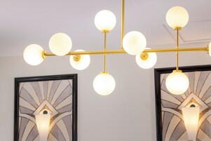 A chandelier with multiple spherical light fixtures suspended from a gold metal frame.