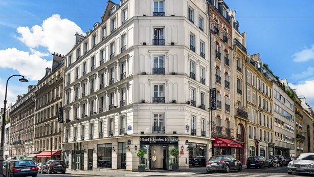 A corner building with a cafe and a hotel named "Hotel Elysees Bassano" on the ground floor. - Hôtel Elysées Bassano (Paris)