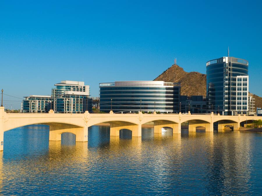 A bridge over water with modern buildings on either side.