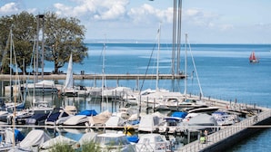 Un port de plaisance avec des bateaux amarrés, une promenade piétonne et une vue dégagée sur la mer.