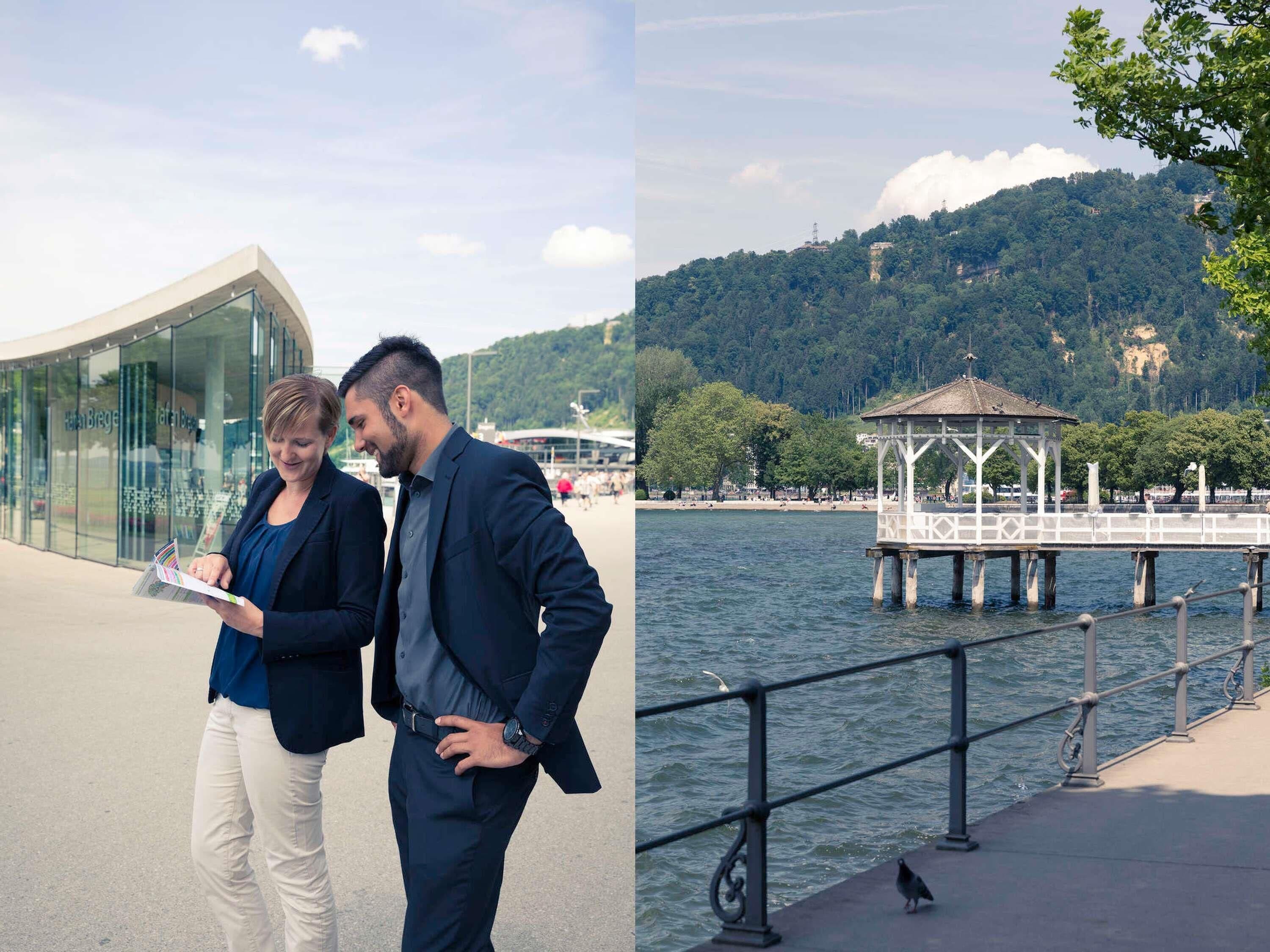 Un edificio moderno con fachada de vidrio, un muelle con quiosco y un lago con una colina boscosa al fondo.