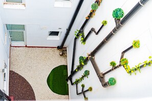 Unique pipes and lush greenery adorn the exterior of this building, blending functionality and style.