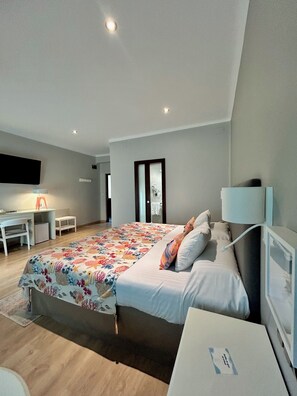 Un dormitorio moderno con una cama grande, un escritorio y una silla.