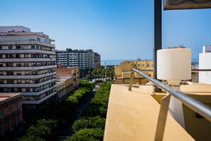 Un edificio alto con varios balcones que dan a un paisaje urbano y una masa de agua.