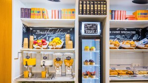 Una barra de desayuno con un letrero de pizarra que dice "Breakfast Library", una cesta de frutas y una cafetera.