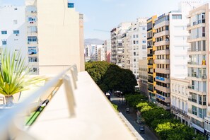 Residents enjoy balconies with railings and potted plants.