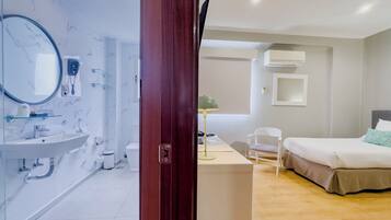 Une chambre d’hôtel avec salle de bain, un bureau et un lit.