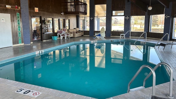 Una piscina cubierta con agua cristalina, una silla de salvavidas y un cartel que indica una profundidad de 30 metros.