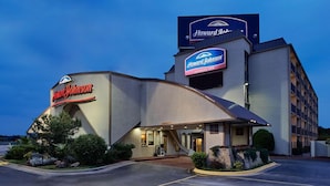 Een Howard Johnson Express Inn hotel met een modern design, herkenbaar aan een opvallend bord en een parkeerplaats.