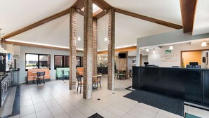 Un vestíbulo de hotel con mostrador de recepción, zona de estar y vistas al exterior.