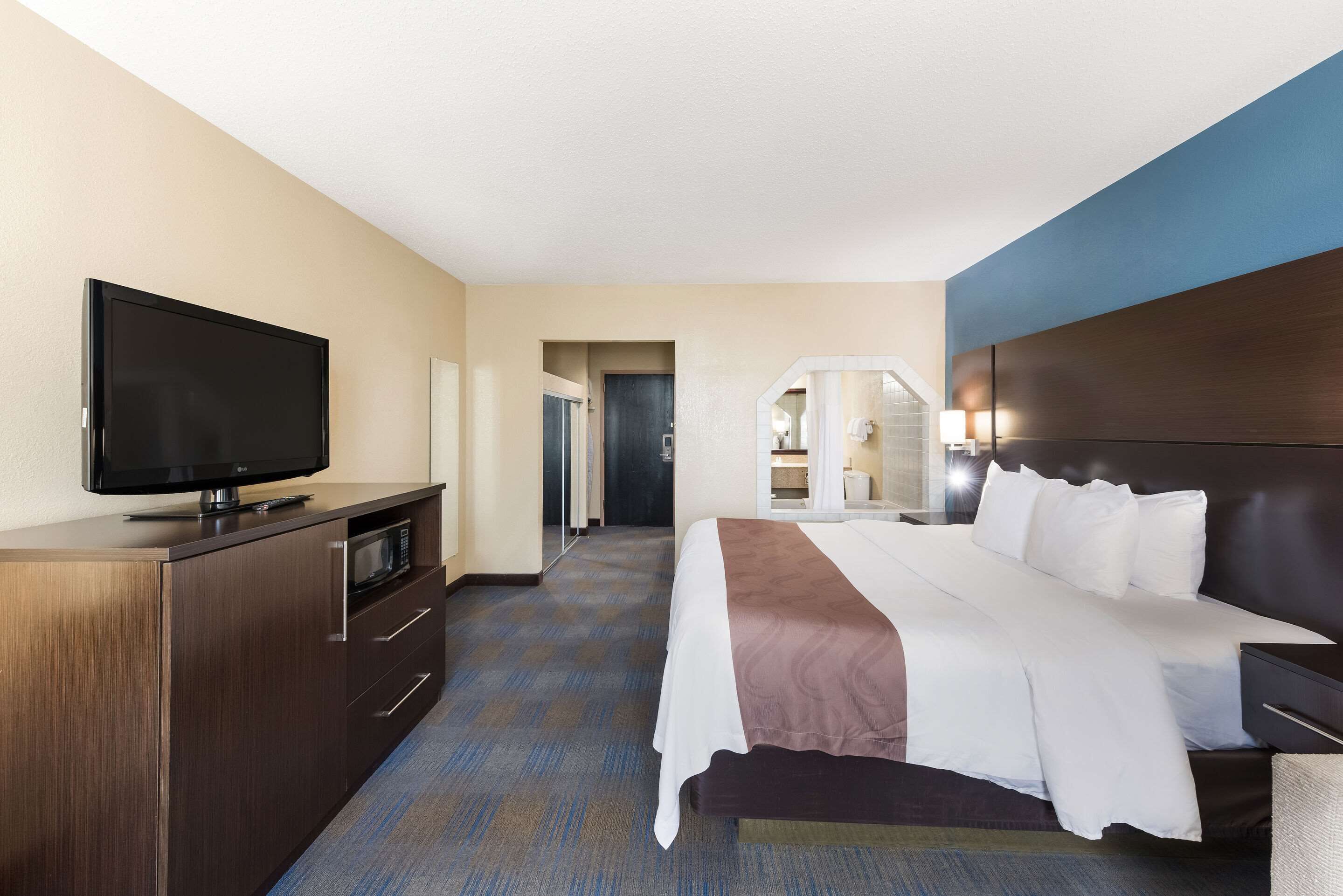 Une chambre d’hôtel équipée d’un lit, d’une télévision, d’un bureau et d’un four à micro-ondes.