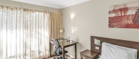 Espacio para trabajar con laptop y tabla de planchar con plancha