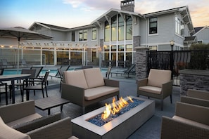 A patio area with outdoor furniture, a fire pit, and a pool.