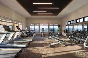 A gym with treadmills, elliptical machines, and weight equipment.
