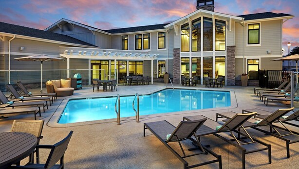 Un hôtel moderne doté d’une piscine, d’un espace extérieur aménagé et d’un patio couvert.