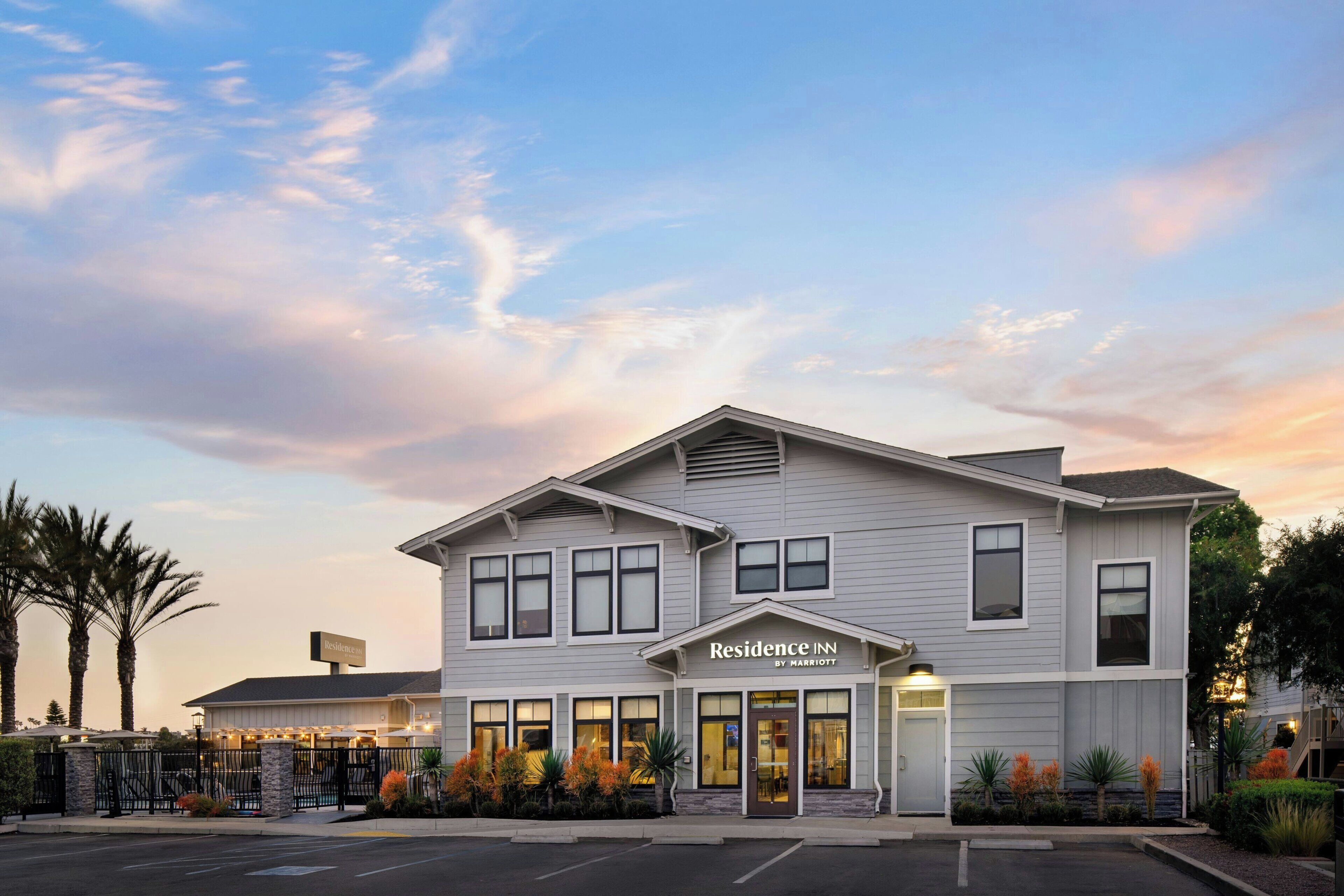 A two-story hotel with a flat roof, large windows, and a sign indicating it is a Marriott property.