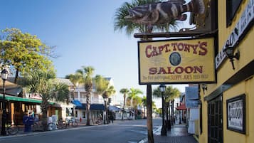 Une vue d’une rue avec une enseigne indiquant « Capt. Tony’s Saloon » et une sculpture de poisson au-dessus.