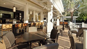 An outdoor patio area with wicker furniture, a bar, and a television. - Fairfield Inn and Suites by Marriott Key West (Key West)