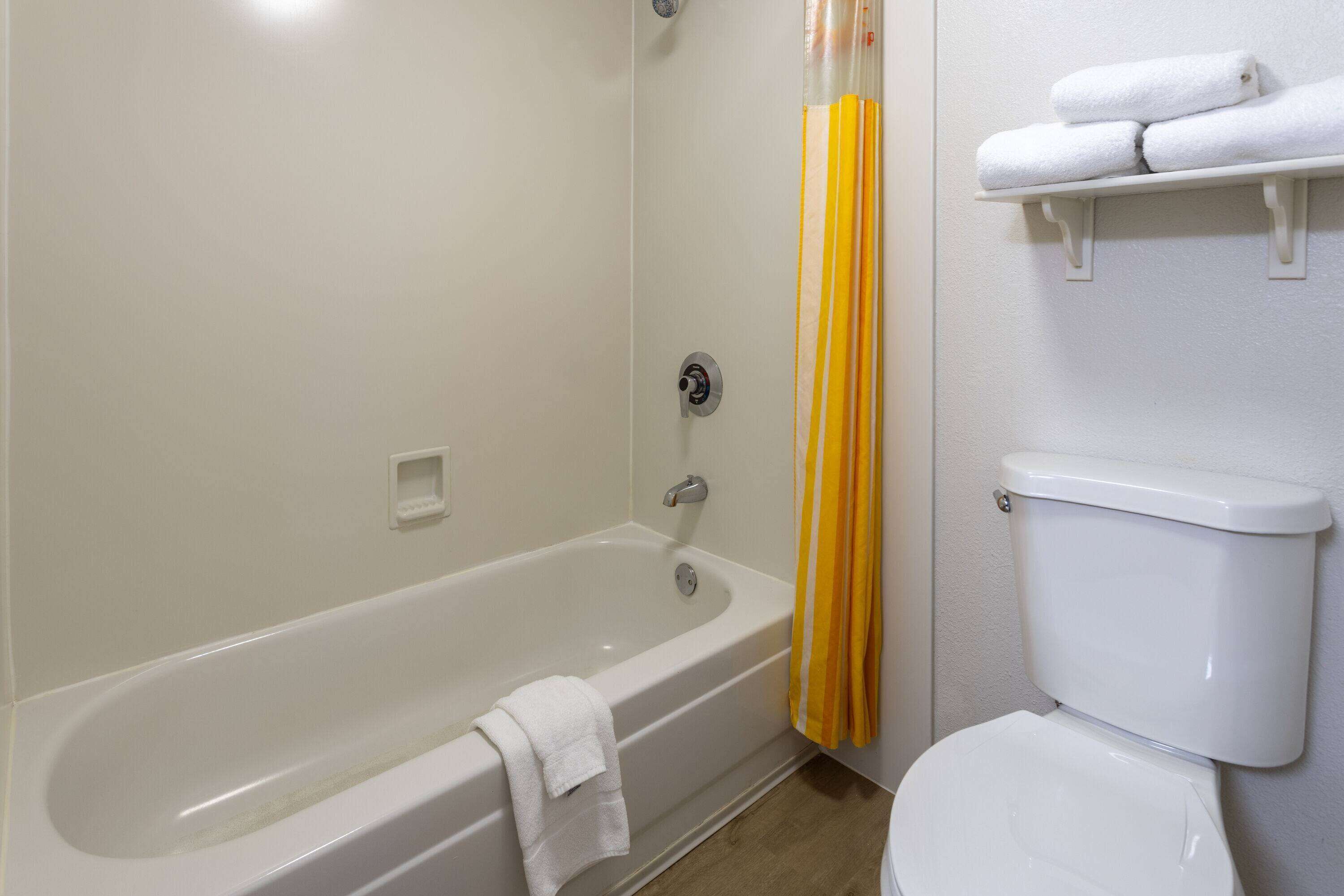 Un baño con bañera, inodoro y toallero.