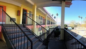 A multi-story motel with a curved facade, balconies, and a central staircase. - Lake Place Inn (Lake Havasu City)
