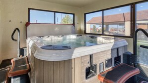 A hot tub with steps and a window view.