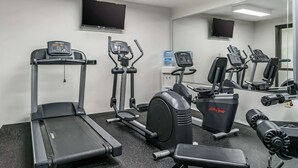 A gym with treadmills, elliptical machines, and weight equipment.