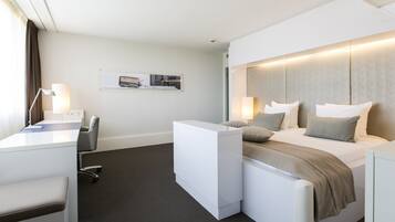 Een moderne hotelkamer met een bed, nachtkastjes, een bureau en een stoel.