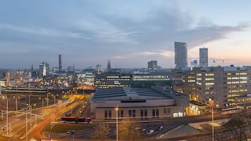 Un paysage urbain avec des bâtiments modernes, un bâtiment circulaire central et des rues animées.