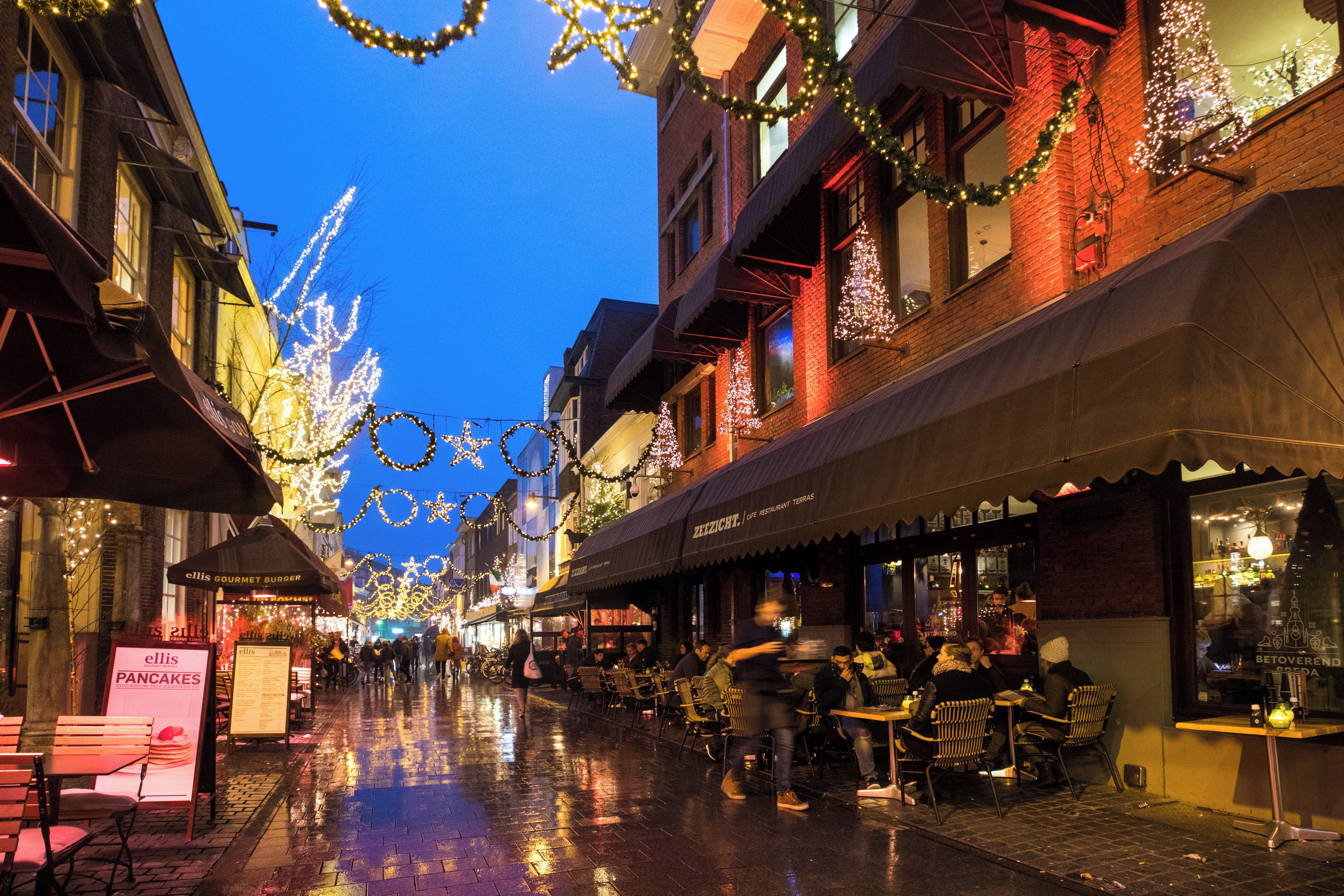 A street lined with buildings, some with awnings and signage, under a night sky.