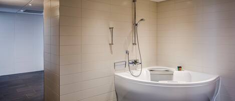 Un baño moderno con una bañera independiente, un cabezal de ducha y un panel de control.