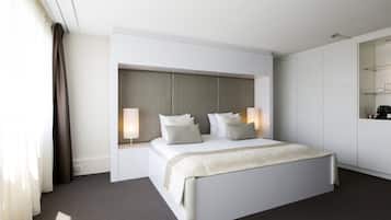 A modern hotel room with a large bed, bedside lamps, a headboard, and a wardrobe.