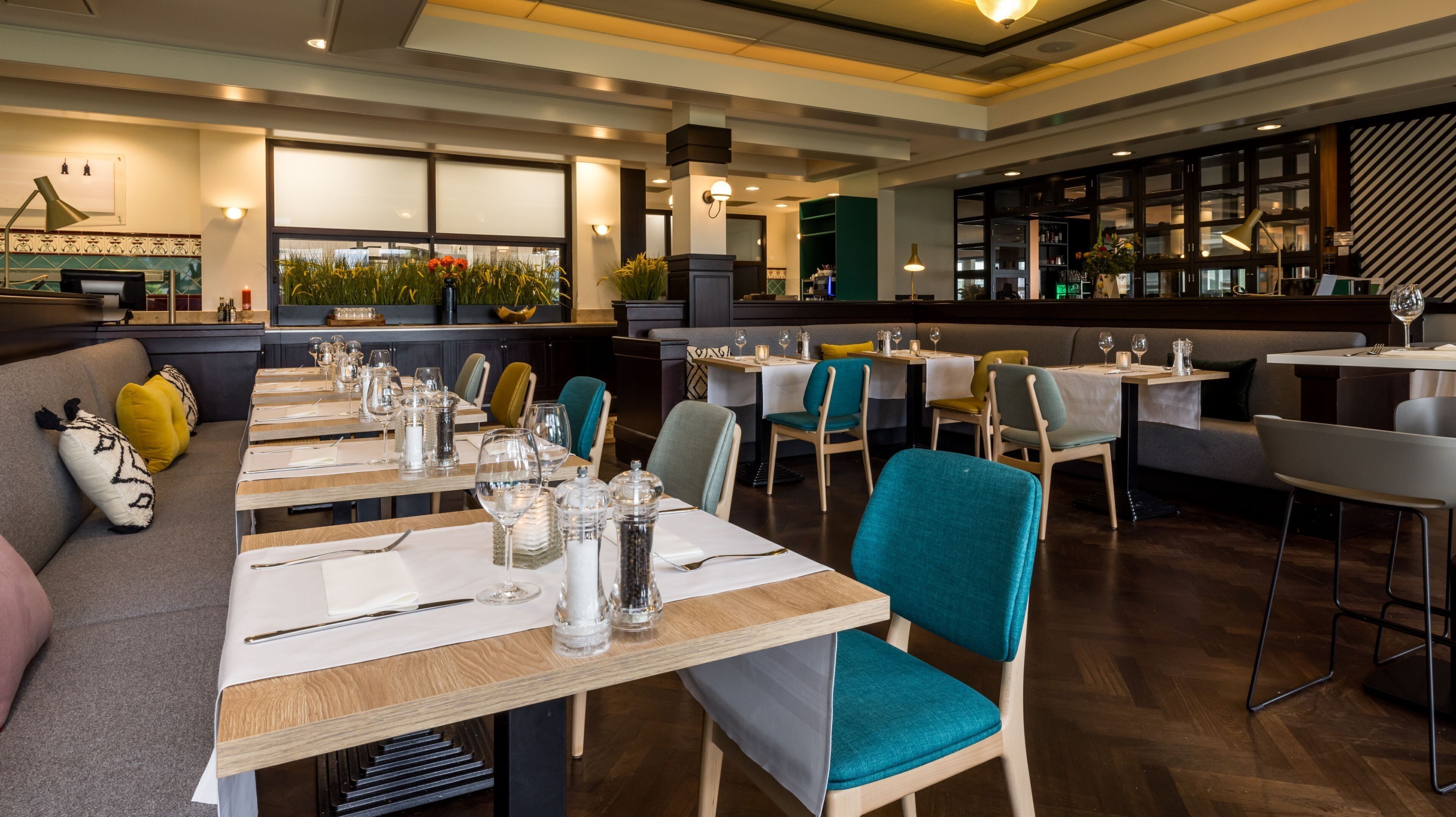 A restaurant with multiple tables, chairs, and a bar area.