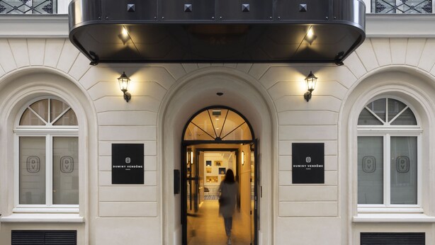 Fachada de hotel clásica con ventanas arqueadas y un acceso central.